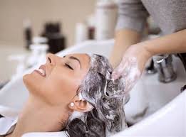 Woman gently washing knotless braids with a sulfate-free shampoo