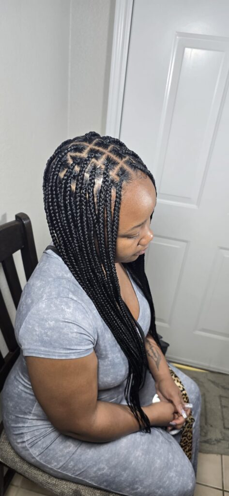Happy client showing off fresh braids at Zealous Braids salon